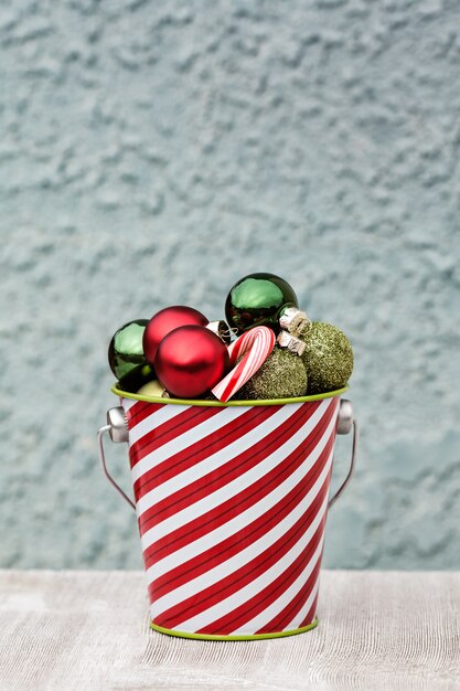 Foto festliche kleine kugeln für weihnachten in gestreiften eimer gesammelt