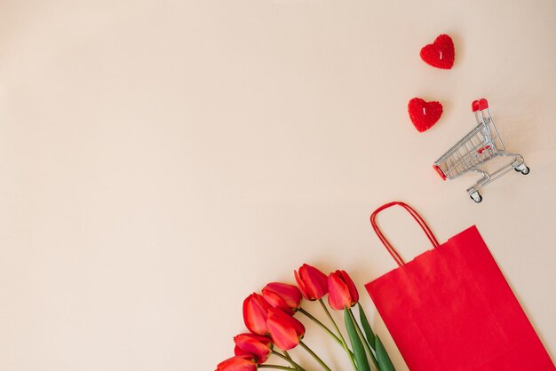 Festliche Komposition Geschenkpapier rote Tasche Herzen ein Strauß Tulpenblumen mit einem Einkaufskorb