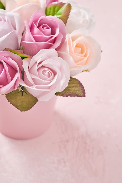 Festliche Komposition mit schönen zarten Rosenblumen im rosa runden Kasten auf hellrosa Hintergrund. Flache Lage, Kopierraum. Grußkarte.