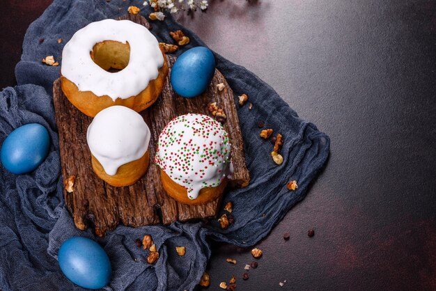 Festliche Kuchen mit weißer Glasur, Nüssen und Rosinen mit Ostereiern auf dem festlichen Tisch. Vorbereitungen für Ostern