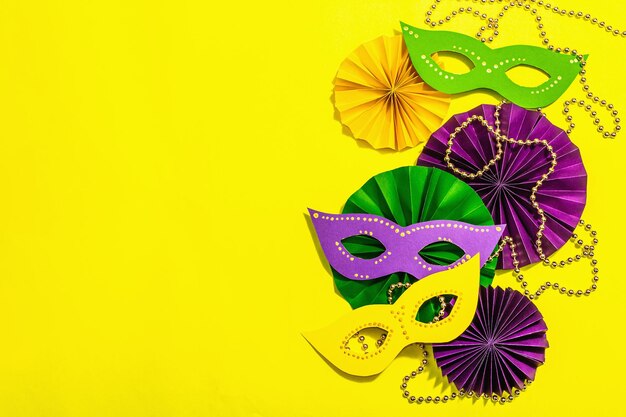 Festliche Mardi Gras Maskerade gelber Hintergrund Faschingsdienstag Karnevalsmasken Perlen traditionelles Dekor