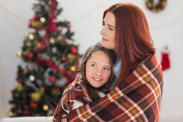 Festliche Mutter und Tochter in Decke gewickelt