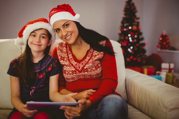 Festliche Mutter und Tochter mit Tablet