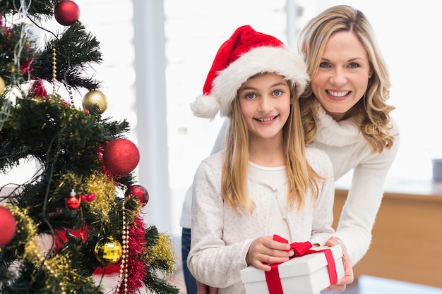 Festliche Mutter und Tochter neben Weihnachtsbaum