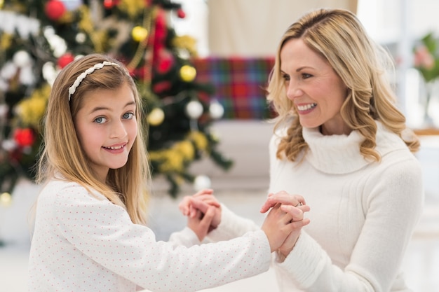 Festliche Mutter und Tochter neben Weihnachtsbaum