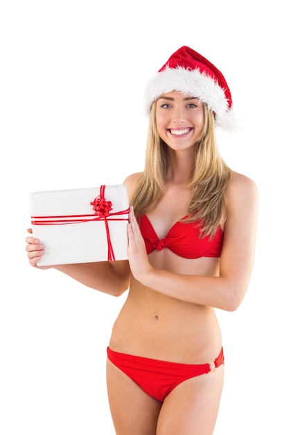 Festliche Sitzblondine im roten Bikini, der Geschenk zeigt
