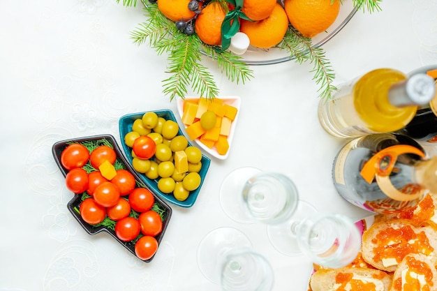 Festliche snacks mit oliven, kirschtomaten und käse in tellern in form eines weihnachtsbaumes