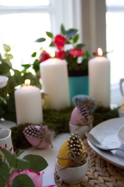 Foto festliche tischdekoration und frühlingsdekor mit kerzen, ostereiern und blumen