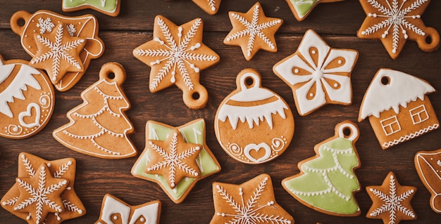 Festliche Weihnachtslebkuchenplätzchen in Form eines Sternes liegen auf einem hölzernen dunkelbraunen Hintergrund.