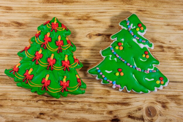 Festliche Weihnachtslebkuchenplätzchen in Form von Weihnachtsbaum auf Holztisch. Ansicht von oben