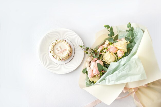 Festlicher Bento-Kuchen und Blumenstrauß auf einem hellen Hintergrund