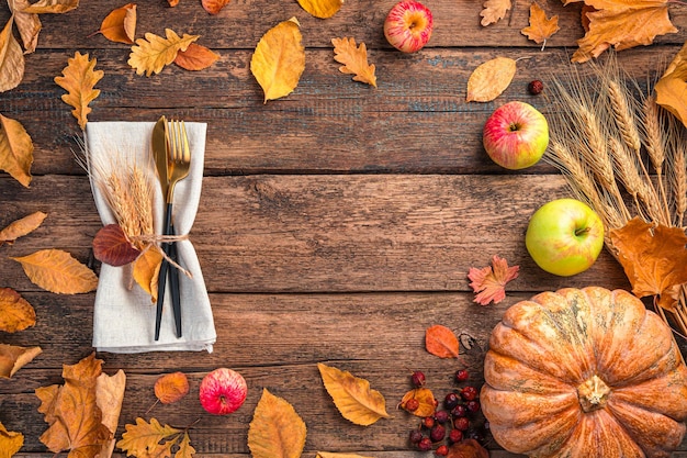 Festlicher Herbsthintergrund mit Besteckkürbisäpfeln und Herbstlaub