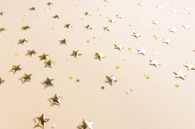 Festlicher Hintergrund mit Funkeln in Form von goldenen Sternen auf einem Hintergrund von Pastellfarben