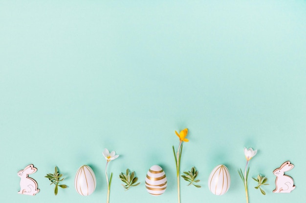 Festlicher osterrahmen aus ostereiern und frühlingsblumenkrokus auf blauem hintergrund stilvolle eas