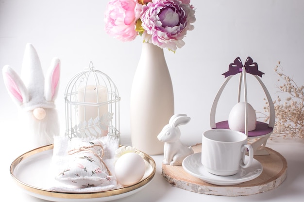 Festlicher Ostertisch mit weißen Eiern und einem Blumenstrauß in einer Vase Helle Ostern