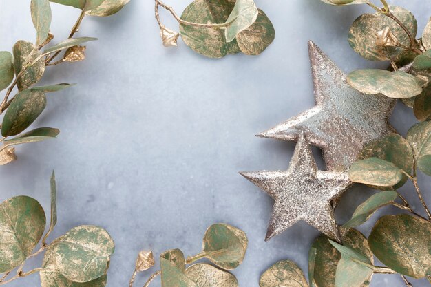 Festlicher Pastellhintergrund. Weihnachtssterne und leuchtender Glitzer, Konfetti auf pastellfarbenem Hintergrund. Weihnachtshintergrund, flache Lage.