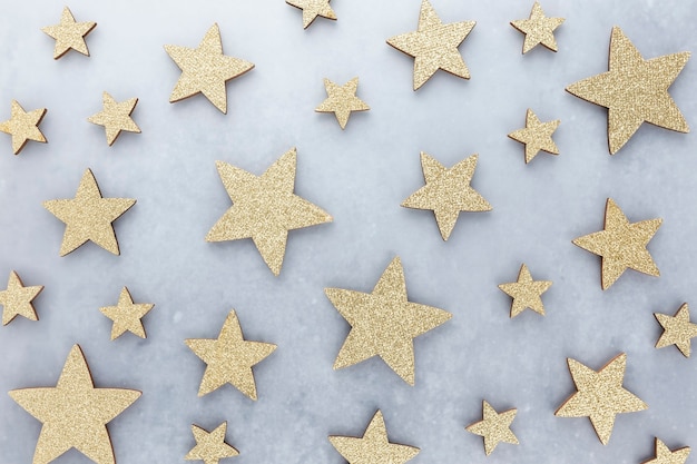 Foto festlicher pastellhintergrund. weihnachtssterne und leuchtender glitzer, konfetti auf pastellfarbenem hintergrund. weihnachtshintergrund, flache lage.