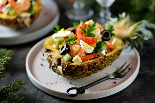 Festlicher Salat aus Garnelen, Kiwi, Oliven, Weichkäse, Wachteleiern, Kirschtomaten in Ananastellern.