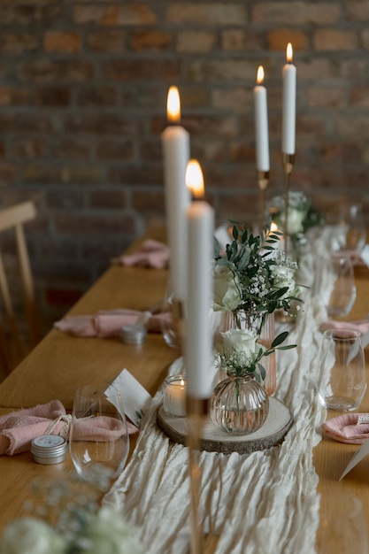 Festlicher Tisch mit rustikalen Kerzen, geschmückten Blumen