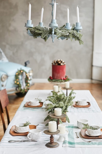 Festlicher Tisch zum Weihnachtsbrunch mit schönen festlichen Gerichten, Glas, Kandelabern mit Kerzen und Tannenzweigen. Heiligabend.