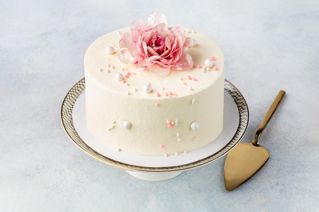 Festlicher weißer Kuchen, dekoriert mit Blumen auf hellem Hintergrund Süßigkeiten-Konzept für Muttertag Hochzeitstag Valentinstag