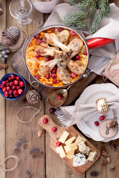 Festliches Abendessen auf einem hölzernen Hintergrund, Reis mit Huhn und Beeren, Käse geschnitten