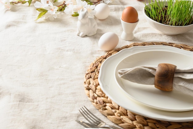 Festliches Abendessen zu Ostern mit frischen Blumen des Eierhasen