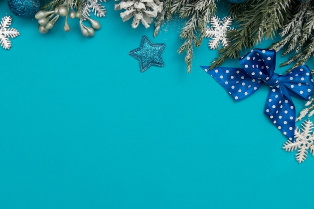 Festliches Konzept der Winterferiendekorationskarte: Weihnachtsbäume, Sterne, Kiefern auf blauem Hintergrund mit Kopienraum