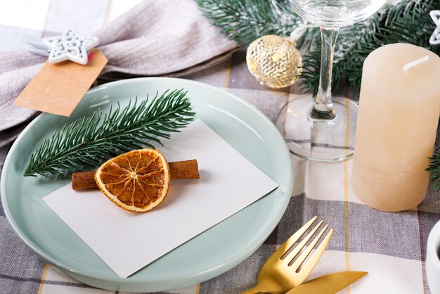 Festliches Weihnachts- und des neuen Jahresdetailsgedeck mit trockener Orange und Zimt auf einem grauen Gewebe. Essplatz eingerichtet