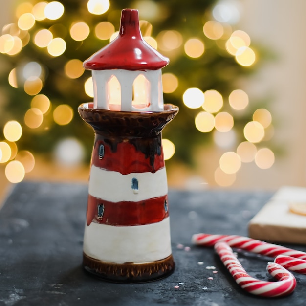 Festliches Weihnachtsstillleben mit Kerzenhalter-Zuckerstangen und Dekorationen von Bokeh-Hintergrund