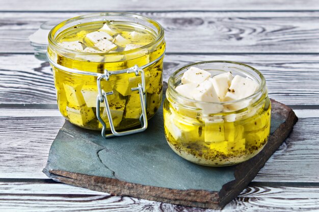 Feta marinado en un baño de vidrio sobre un fondo de madera