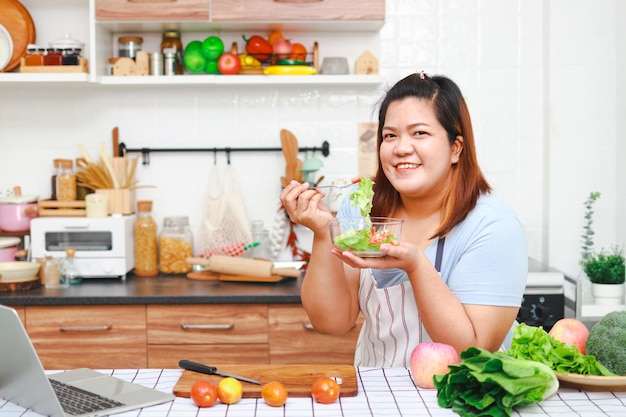 Fette asiatische Frau, die in der Küche kocht Lernen Sie, Salate und gesunde Lebensmittel aus dem Gesundheitskonzept der sozialen Medien zuzubereiten Essen Sie gesunde Lebensmittel, um Gewicht zu verlieren