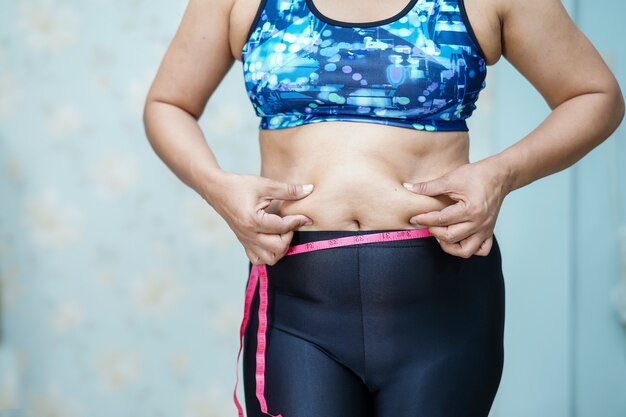 Fetter Bauch der überladenen asiatischen Frauenshow im Büro.