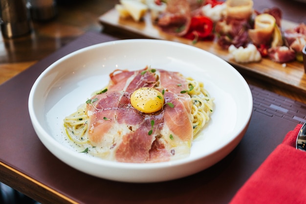 Fettuccine Carbonara con jamón de Parma y yema con pimienta negra.