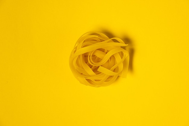 Fettuccine caseiro isolado no fundo amarelo