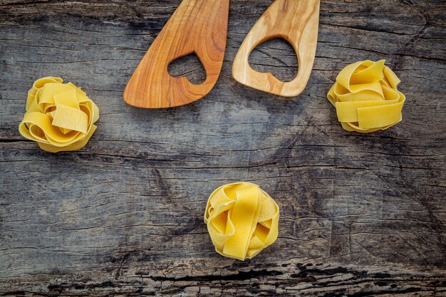 Fettuccine casero secado en fondo de madera oscuro.