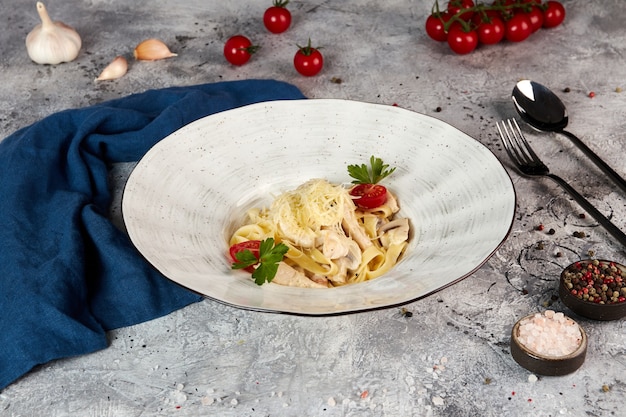 Fettuccine com frango e cogumelos, fundo cinza