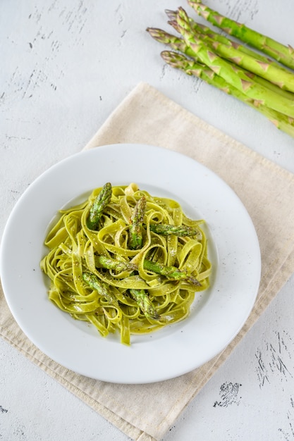 Foto fettuccine de espinacas con espárragos fritos