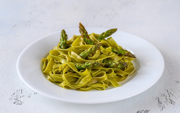 Foto fettuccine de espinacas con espárragos fritos