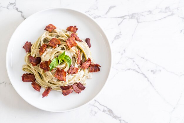 Foto fettuccine de espinacas con queso crema de salsa blanca y tocino