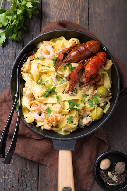 Fettuccine-Nudeln mit Meeresfrüchten, Krebsen, Tintenfischgarnelen, auf Steinpfanne. Gourmetgericht