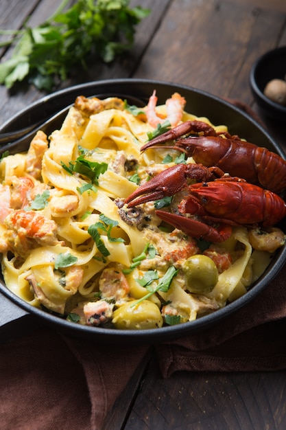 Fettuccine-Nudeln mit Meeresfrüchten, Krebsen, Tintenfischgarnelen, auf Steinpfanne. Gourmetgericht