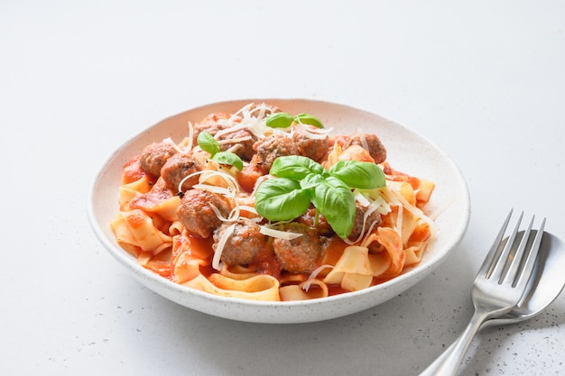 Fettuccine de pasta con albóndigas y salsa de tomate en un tazón