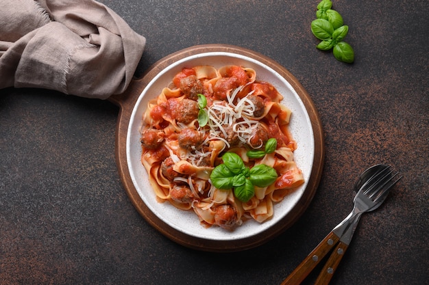 Fettuccine de pasta con albóndigas y salsa de tomate en un tazón