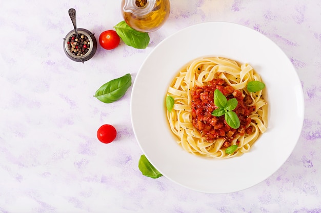 Fettuccine de pasta Boloñesa con salsa de tomate en un tazón blanco.