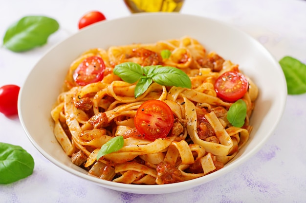 Fettuccine de pasta Boloñesa con salsa de tomate en un tazón blanco.