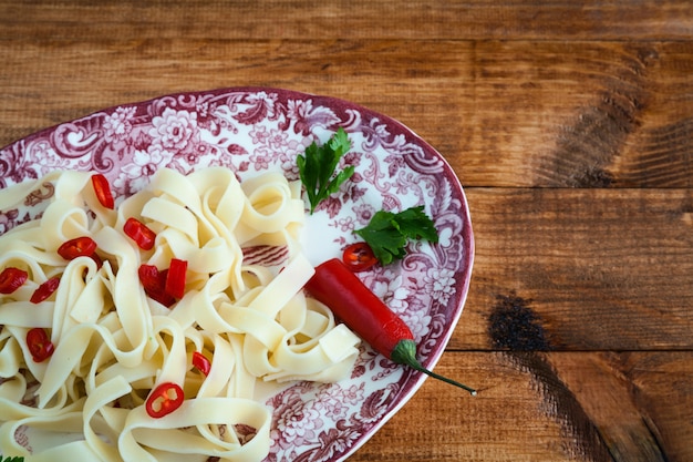 Fettuccini pasta italiana con perejil y pimientos picantes.