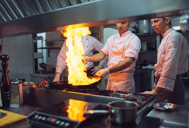 Feuer in der Küche. Feuergas brennt auf Eisenpfanne, Feuer sehr heiß rühren