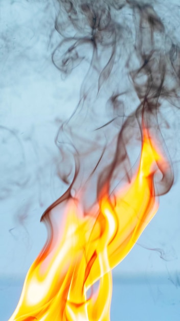 Foto feuer und dichter schwarzer rauch auf hellblauem hintergrund