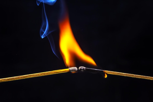 Feuer und Rauch Brennendes und rauchendes Streichholz auf schwarzem Hintergrund Hitze und Licht von der Feuerflamme